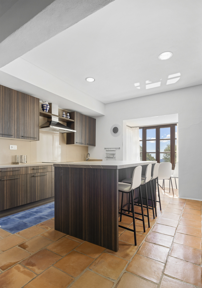 Cocina con isla central y mesa junto a ventana